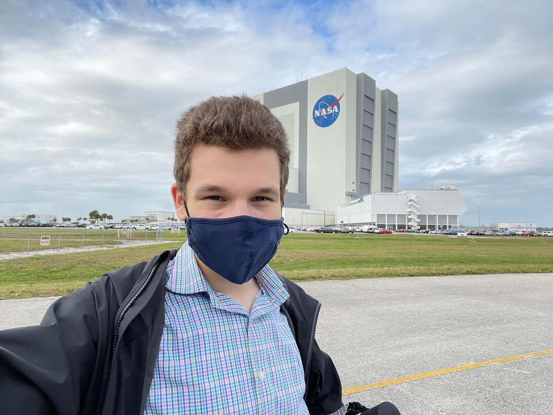 Theo Nelson takes a selfie while wearing a mask in front of the Kennedy Space Center